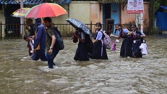School children make their way through water logge 1755561893697 1755561901497